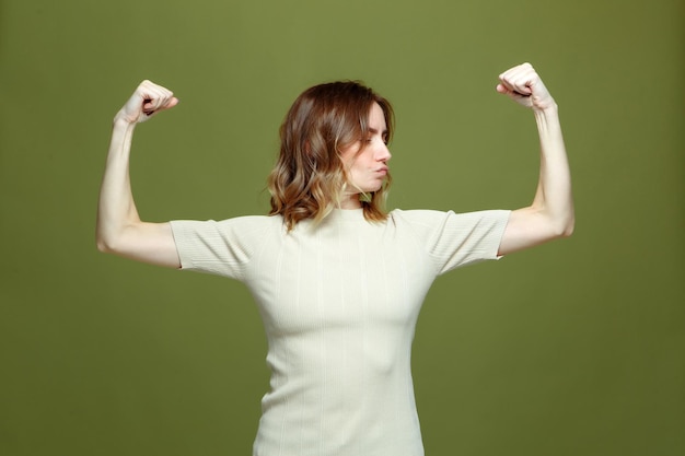 Girl power zelfverzekerde trotse sterke onafhankelijke jonge vrouw die armspieren toont, demonstreert biceps aan