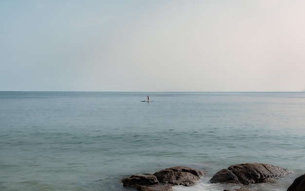 Foto ragazza che pratica il paddle surf in mare