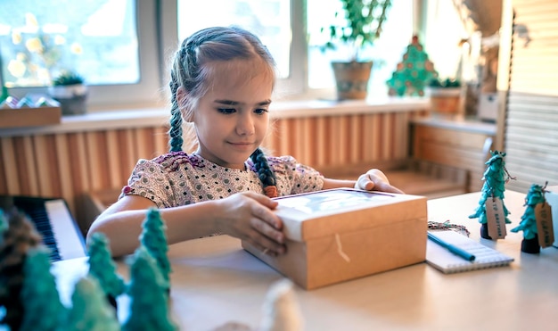 Girl preparing diy gifts and signing tags to family for christmas handmade zero waste holidays