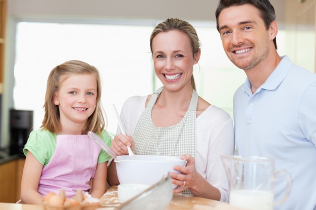 Девочка готовит тесто с родителями