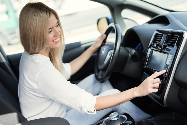 女の子が電気自動車の制御装置のボタンを押す