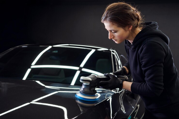軌道磨き機を備えた女性のプロの自動車サービス労働者