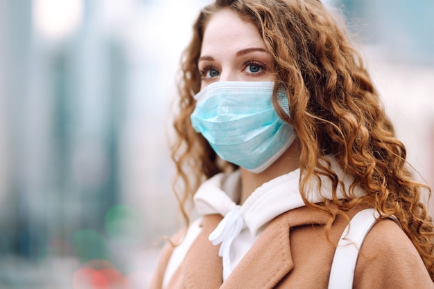 Girl in protective sterile medical mask on her face on the street