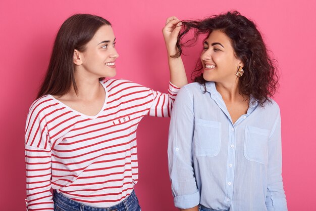 Foto ragazza che tira i capelli ondulati della sua amica