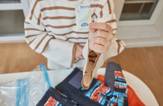 Девушка откачивает воздух пылесосом из вакуумного мешка с одеждой Концепция хранения и транспортировки вещей из одежды Экономия места в герметичном мешке