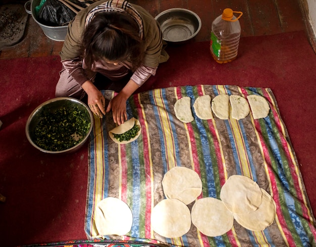 Photo the girl puts spinach leaves in the dough