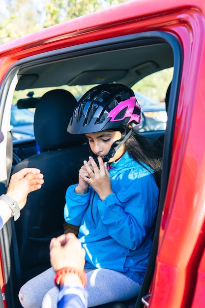 車内で保護用ヘルメットをかぶる女の子