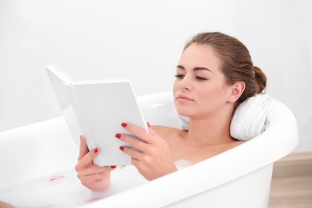 Photo girl reading book in bathtub