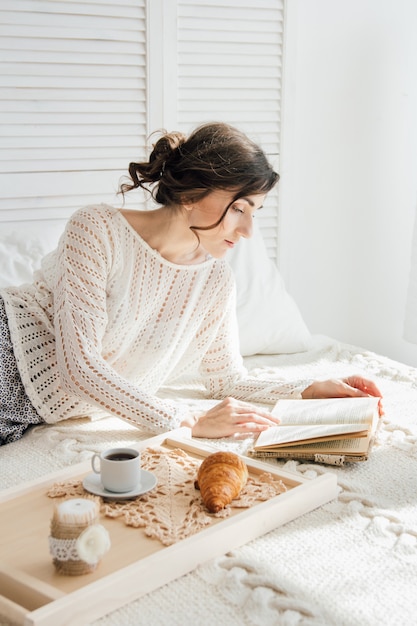 Girl reading a book over Breakfast 