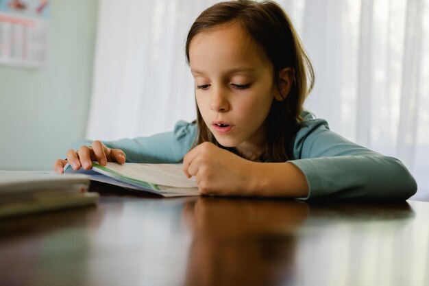 Photo girl reading a book at home