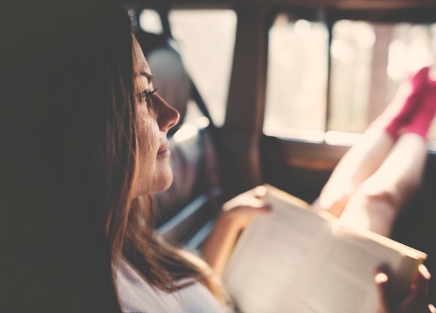 Girl Reading Book Inside Car Concept