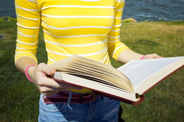 Girl reading a book at the outdoors