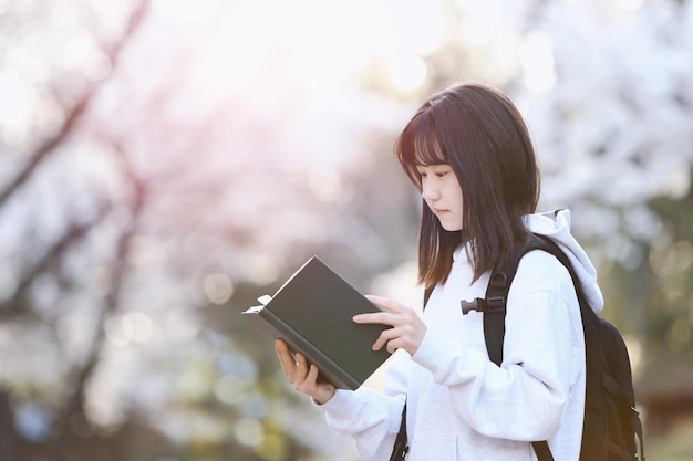 A girl reading a book in a park