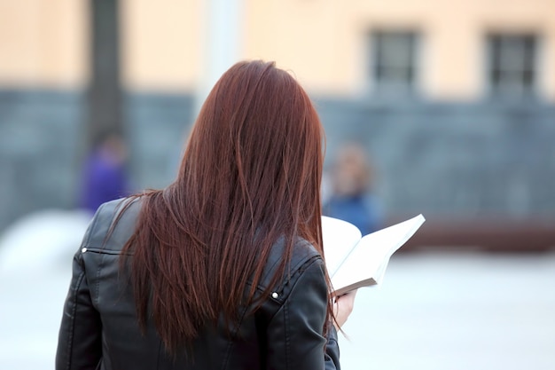 Girl reading a book on the street