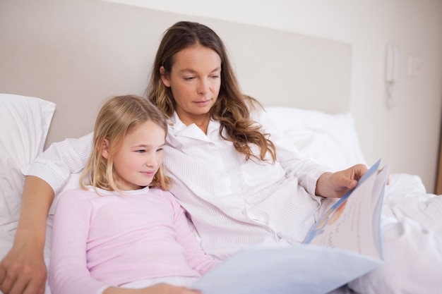 Girl reading a book with her mother