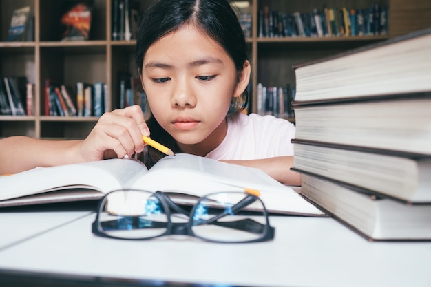 女の子の読書と執筆、図書館での宿題