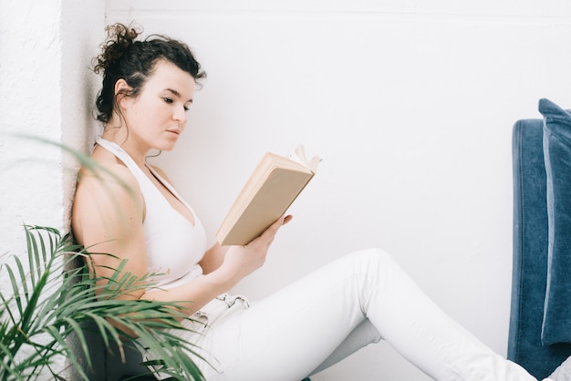 The girl reads a book at home