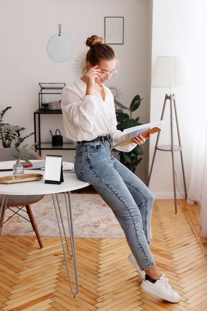 Girl reads a book in the office at lunchtime