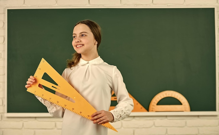 Фотография девушка готова к учебе ученица в школе изучает математику с треугольником в начальной школе ученик учится с геометрическим инструментом снова в школу ребенок с измерительным и счетным оборудованием
