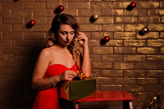 The girl received a gift girl in a red dress holiday gift