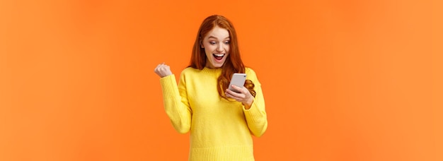 Photo girl received thousand likes under new picture cheerful and triumphing pretty redhead female fist pu