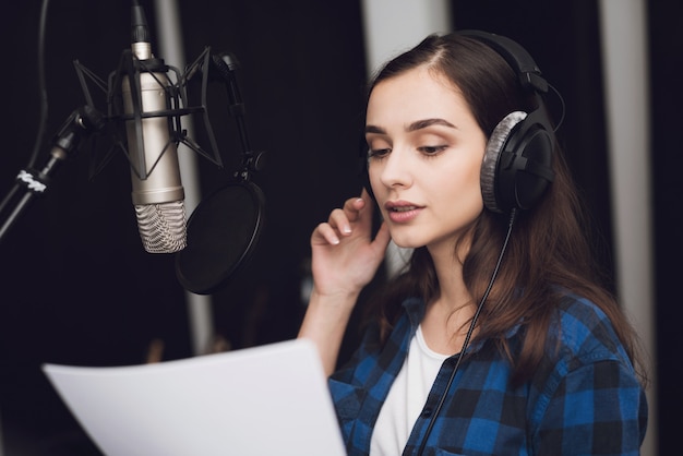 Girl in the recording studio sings a song.