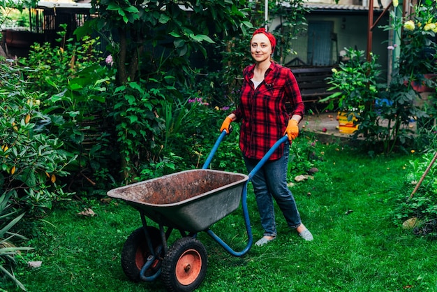 A girl in a red bandana and shirt is harvesting in the garden and vegetable garden