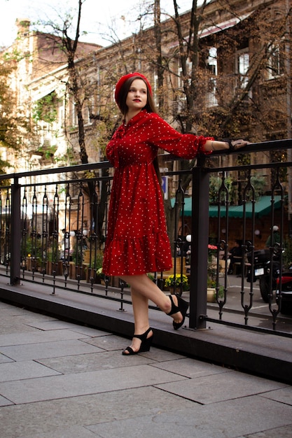 A girl in a red beret walks in the autumn city