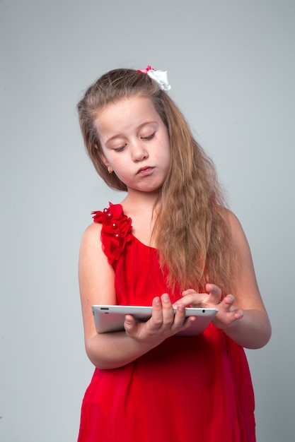 Girl in red dress holding digital tablet