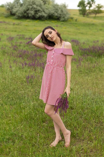 Girl in red dress on nature in summer Portrait of a beautiful girl in the summer in the forest