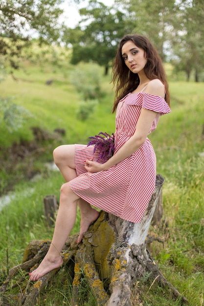 Girl in red dress on nature in summer Portrait of a beautiful girl in the summer in the forest