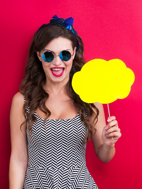 The girl in a red dress on a red background in the studio