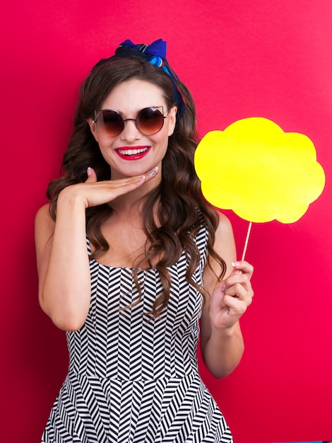 The girl in a red dress on a red background in the studio