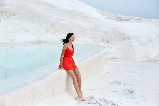 Girl in red dress on white travertines