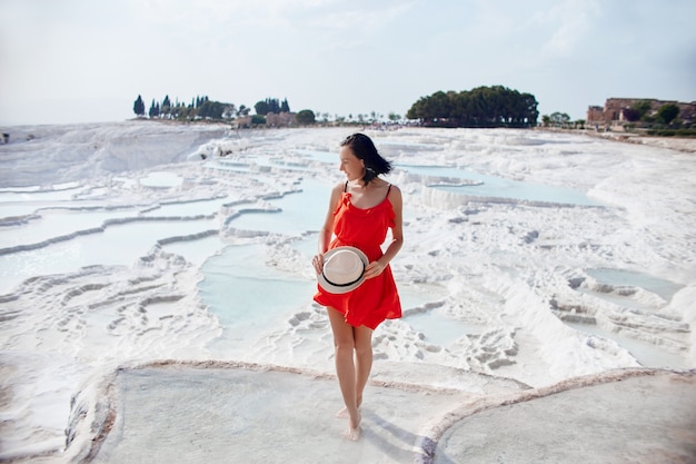 Girl in red dress on white travertines