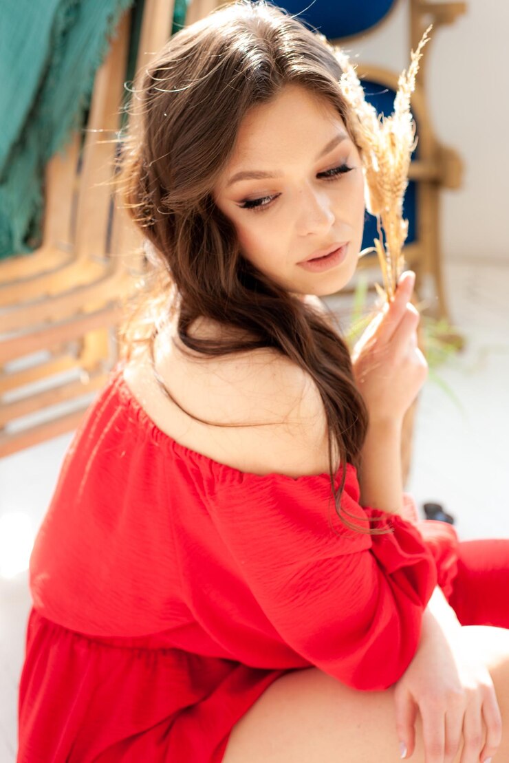 Photo 彼女の髪に花を持つ赤いドレスの女の子