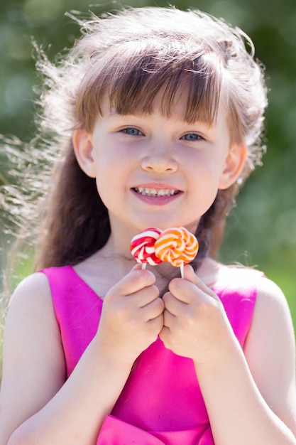 A girl in a red dress with sweets in her hands.