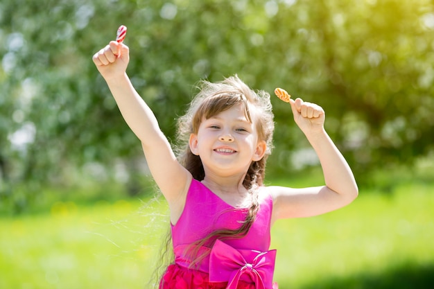 A girl in a red dress with sweets in her hands.