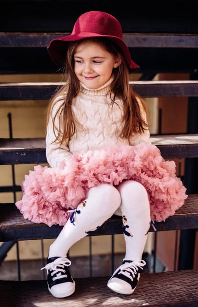 a girl in a red hat without a front tooth on the street