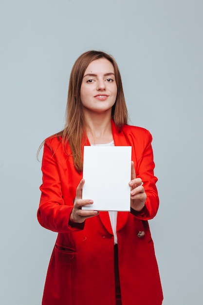 Girl in a red jacket holds a blank notebook