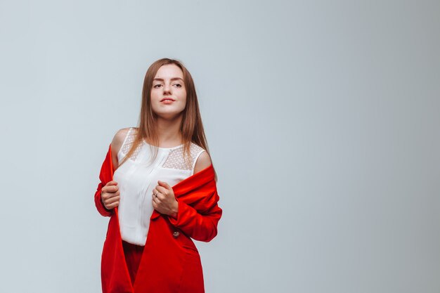 Girl in a red jacket on a light background