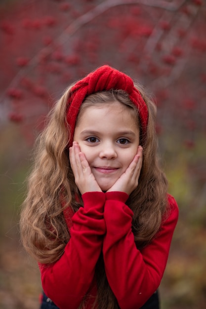 秋の森の赤い服の女の子