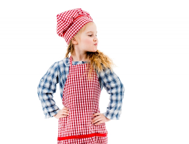 Girl in red plaid apron standing in akimbo pose