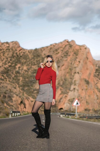 Girl in red posing in the middle of the road