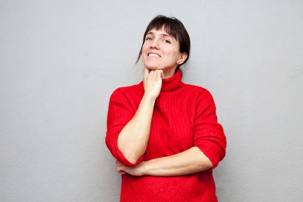 Girl in red sweater on gray wall