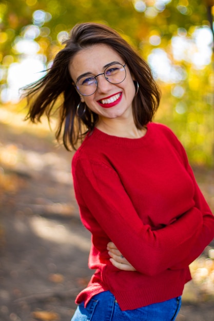 Ragazza in maglione rosso in natura. ragazza in rosso in natura. ragazza con le labbra rosse. foto d'autunno