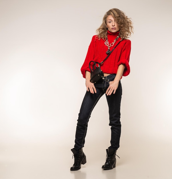 Girl in a red sweater posing on a white background