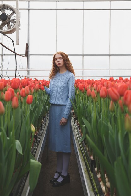 Girl between red tulips