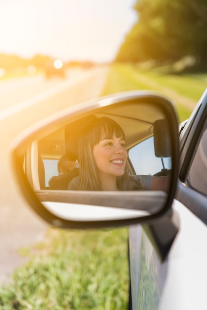 Girl reflected on side mirror