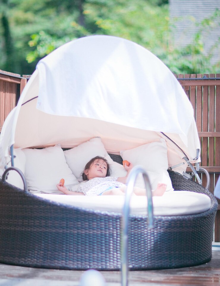 Photo girl relaxing on big lounge chair at poolside